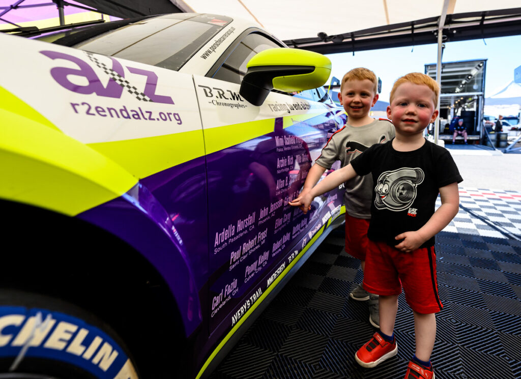 Two young boys point to names of dementia sufferers honored by their families on the Racing to End Alzheimer's Porsche.